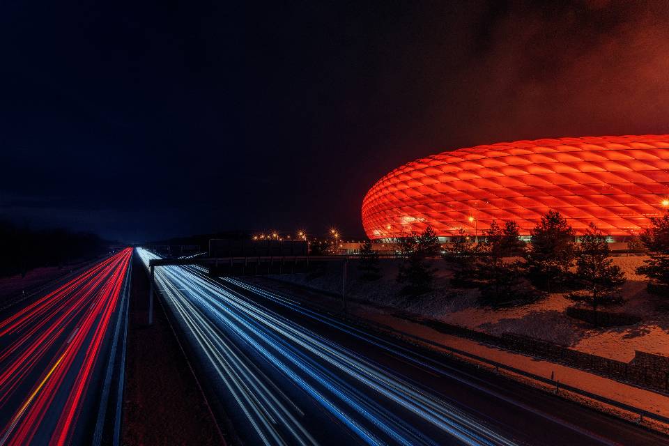 Stadion sepak bola dengan lampu sorot menyala di malam hari
